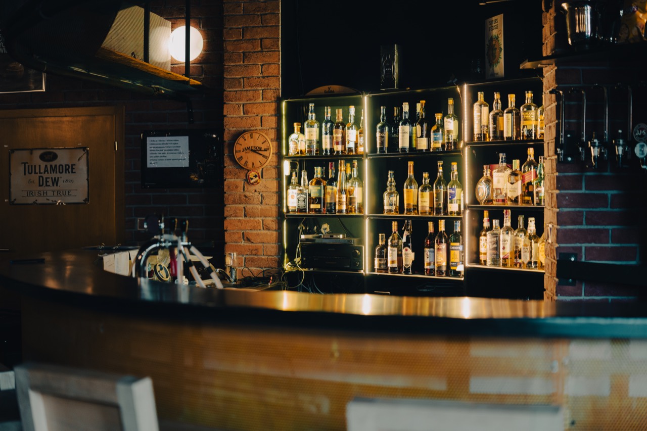 Whisky bar: nasvícené police se skotskými a irskými whisky